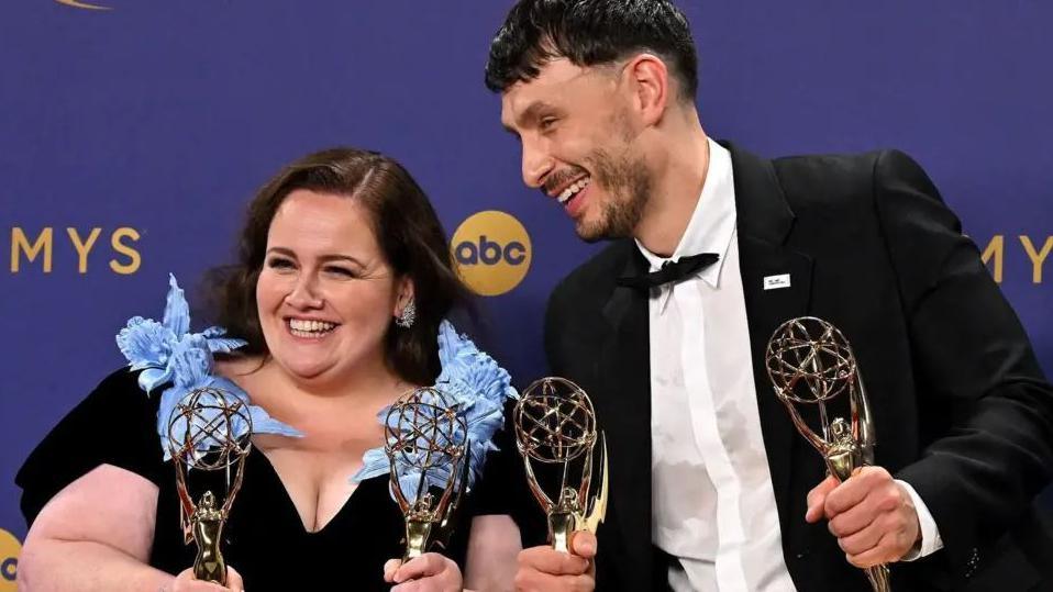 Jessica Gunning and Richard Gadd at the Emmys last year, both in evening dress and smiling, holding two awards each