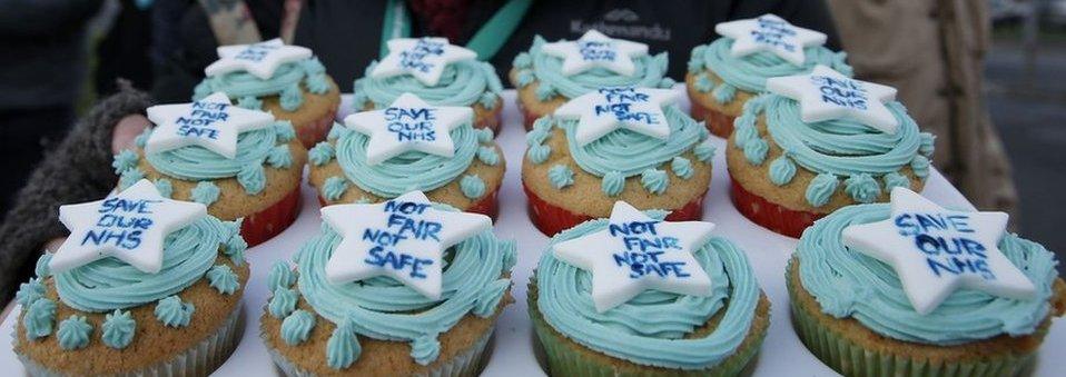 A demonstrator holds a tray of decorated cakes at a protest by junior doctors outside the Frimley Park Hospital in Frimley, south-west London.