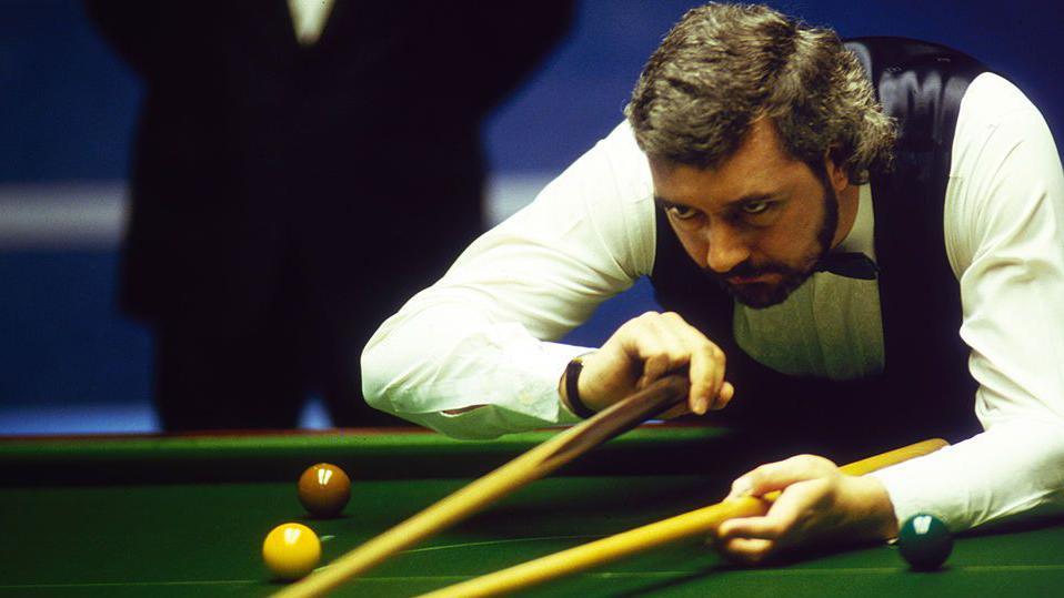 John Virgo lines up a shot using the rest