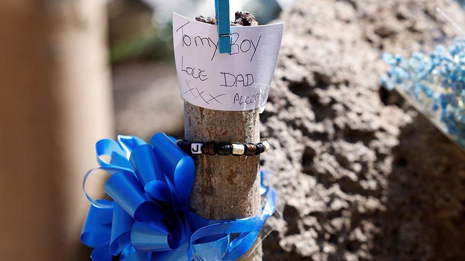 A note and blue riband left by the father of British teenager Jay Slater near to where his body was found