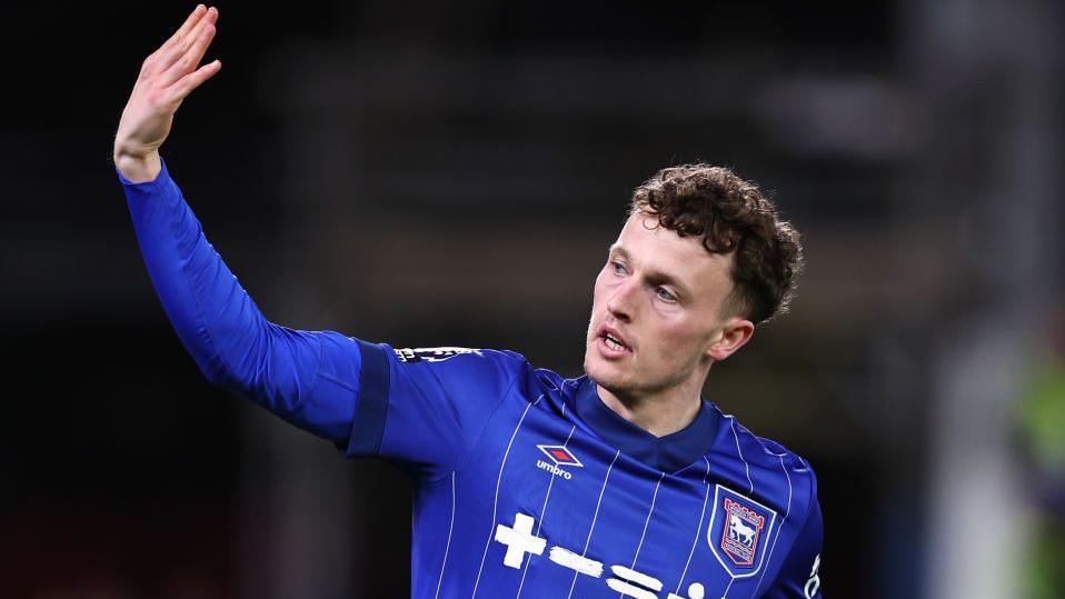 Nathan Broadhead waves at supporters during an Ipswich game