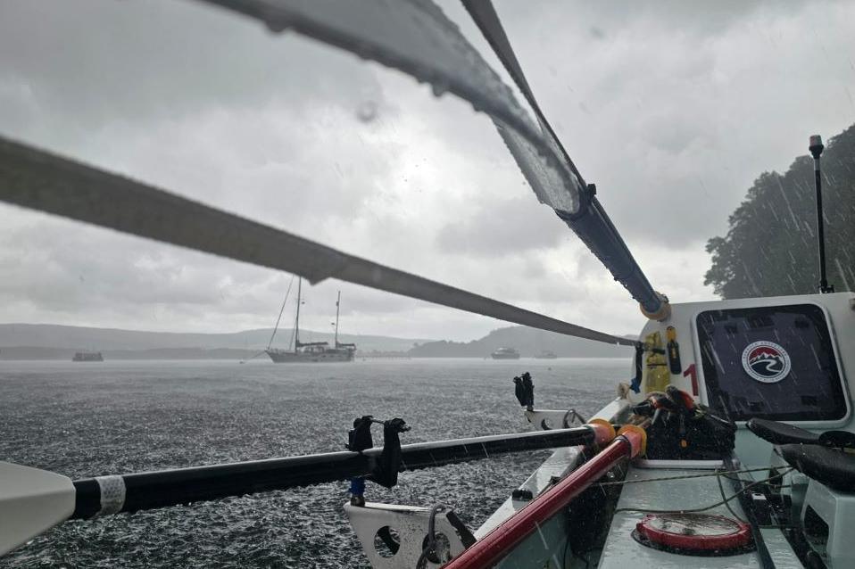 A picture taken from the couple's rowing boat of the bay at Tobermory. A yacht is in the distance.