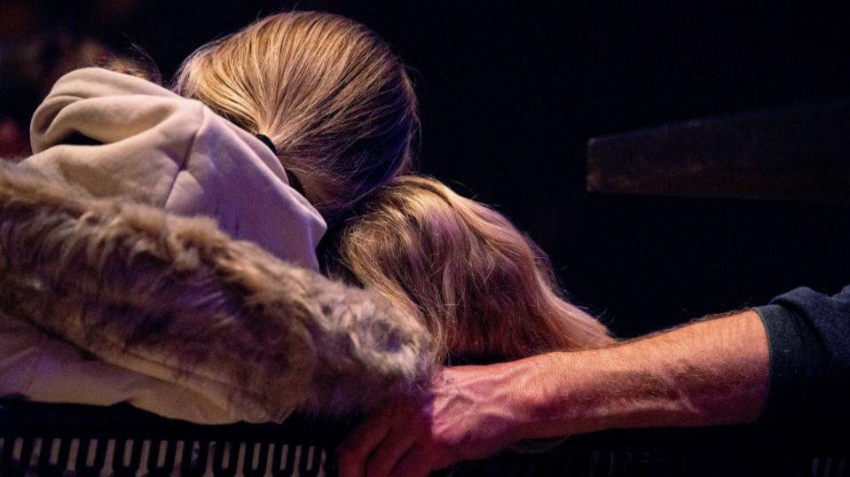 Two girls in church with backs turned