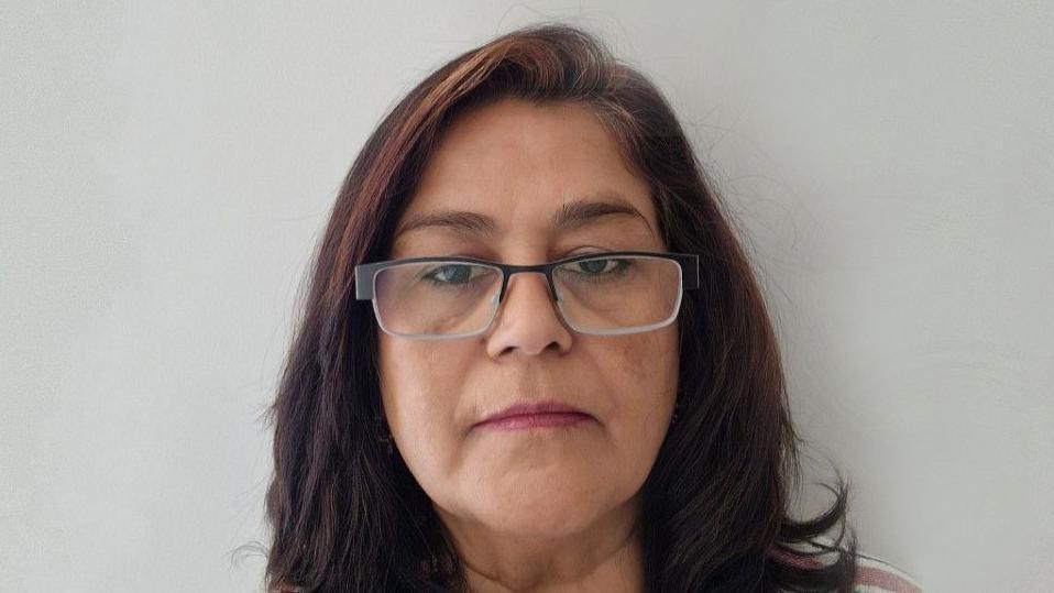 Bindu Parmar, a south Asian woman wearing glasses with shoulder length brown hair