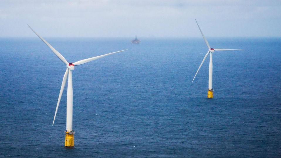 Two wind turbines turn in the North Sea off the coast of Bergen in Norway