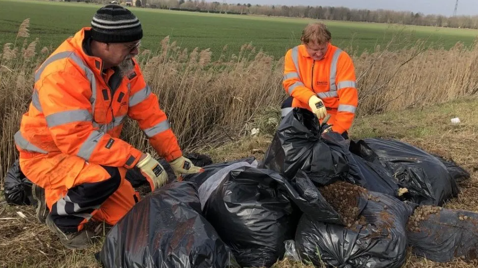 Refuse collectros cleaning the bags of rubbish 