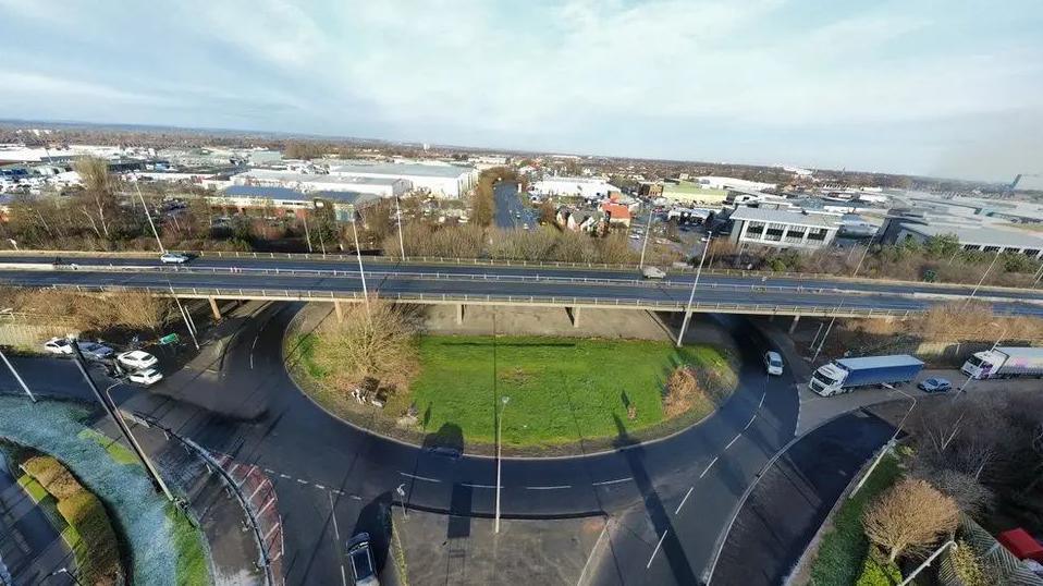 A drone image of the St Andrews Quay Bridge in Hull, showing traffic on the slip roads and a grassy roundabout underneath.