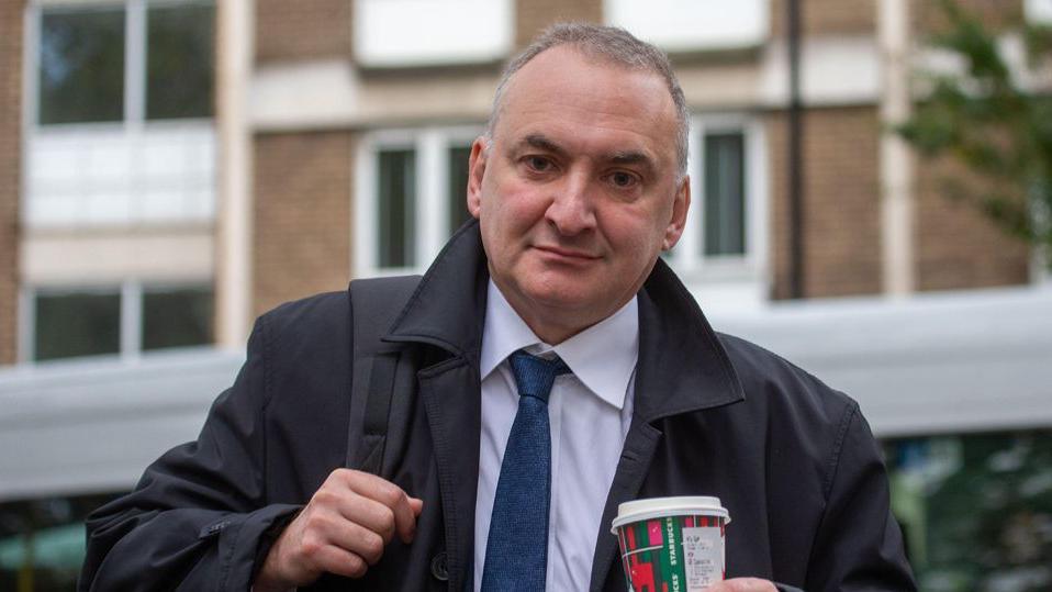 Chris Wormald holding a coffee cup as he arrives at the Covid inquiry in London