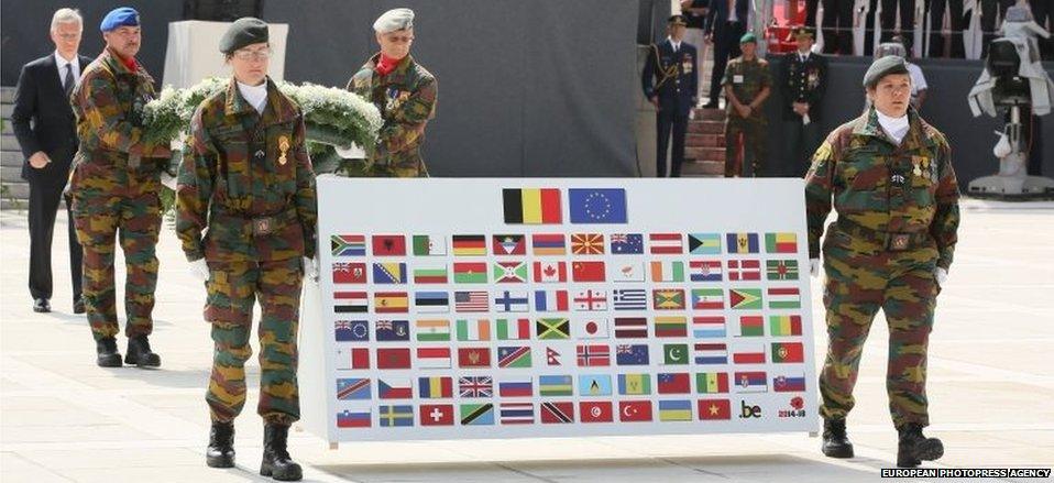 King Philippe of Belgium (far left) lays a wreath