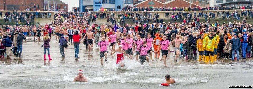 Swimmers run into the sea