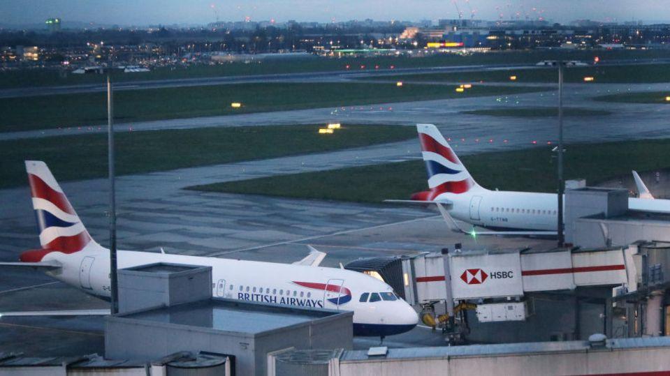 British Airways planes lined up at gates at Heathrow Airport at dawn