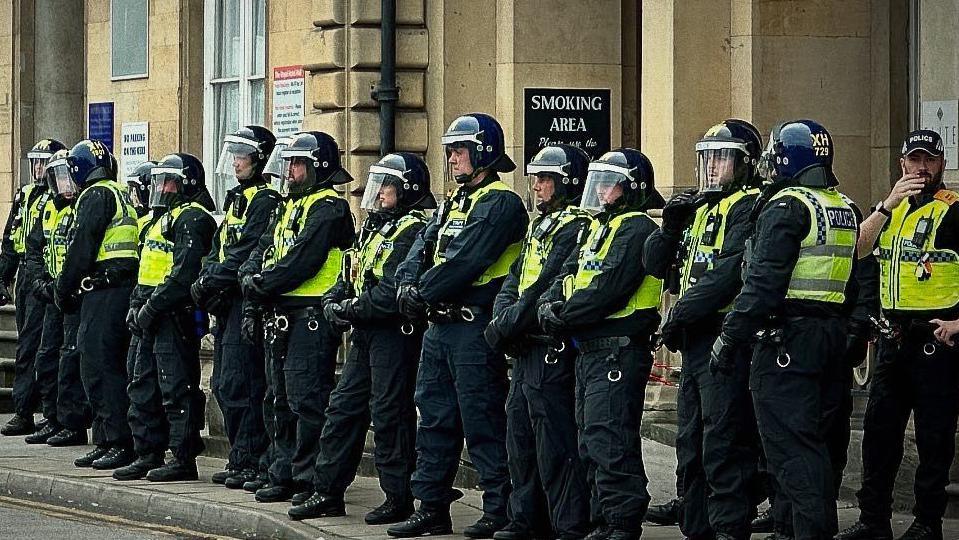 Police officers in protective gear standing in a line in front of the Royal Hotel on Ferensway