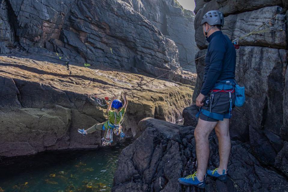 Aden and his dad using a rope to cross between Old Man of Stoer and shore