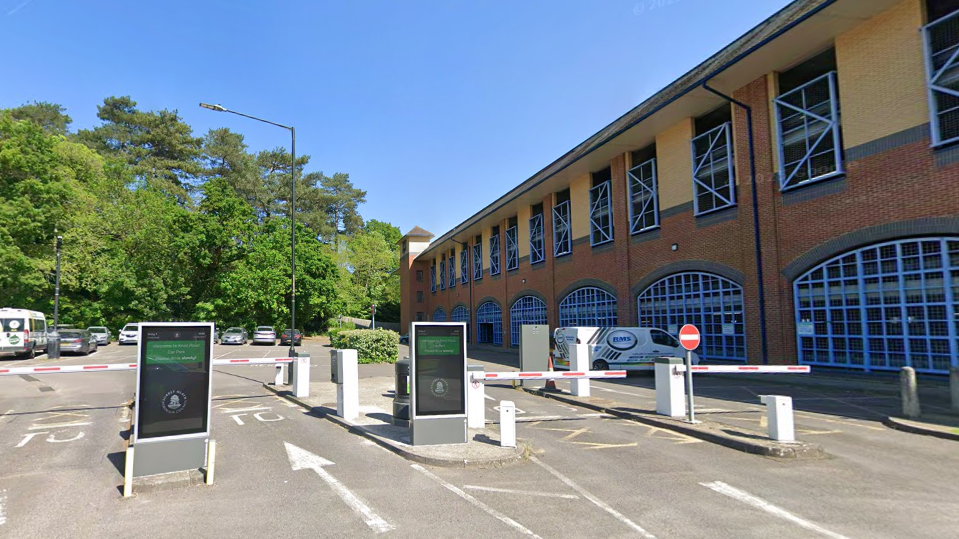 The entrance to Knoll Road car park in Camberley, with several barriers and arrows indicating which way to enter.