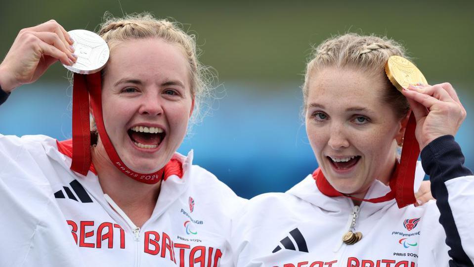 Silver medalist Hope Gordon and gold medalist Charlotte Henshaw pose with their medals on the podium after the women's VL3 final at the 2024 Paris Paralympics