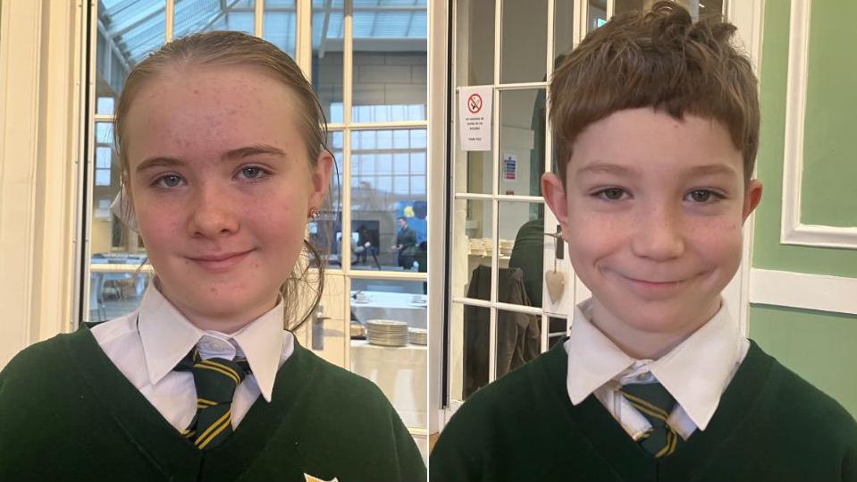 Freya and Jayson, young pupils at St Malachy's Primary school in Belfast.  Freya has long, blonde hair tied back.  Jayson has short, light brown hair.    They are both wearing dark green school jumpers, white shirts and green and yellow striped ties.