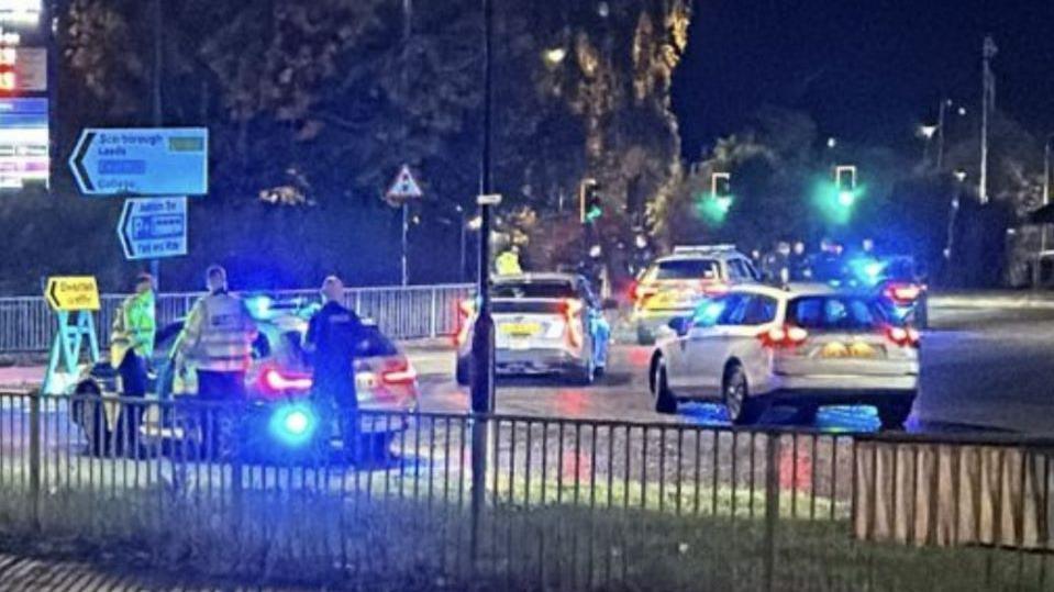 Police vehicles attend the scene of the crash