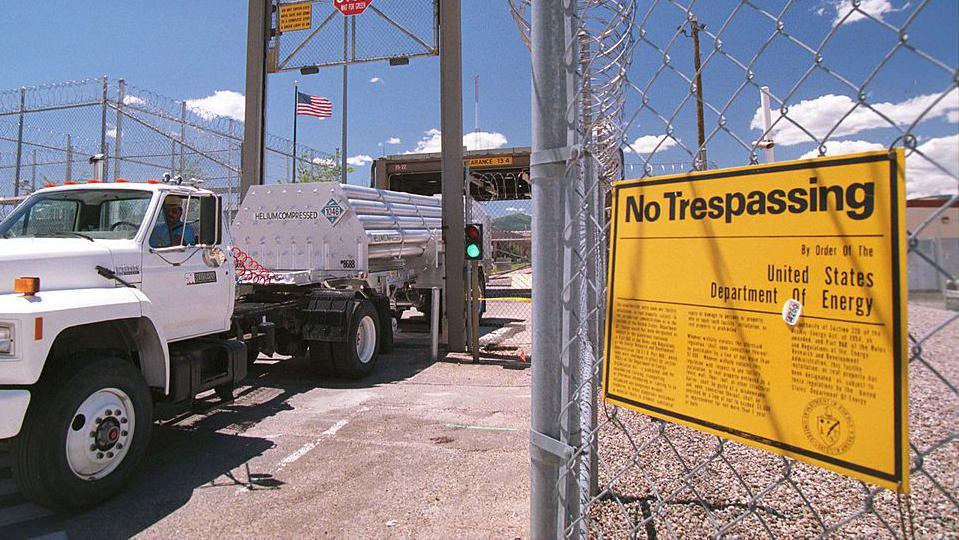 A truck exits the Los Alamos national laboratory, in New Mexico. A sign in the foreground says: "No Trespassing."