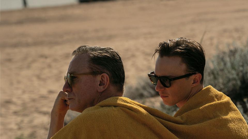 Two men in a desert with a blanket over them