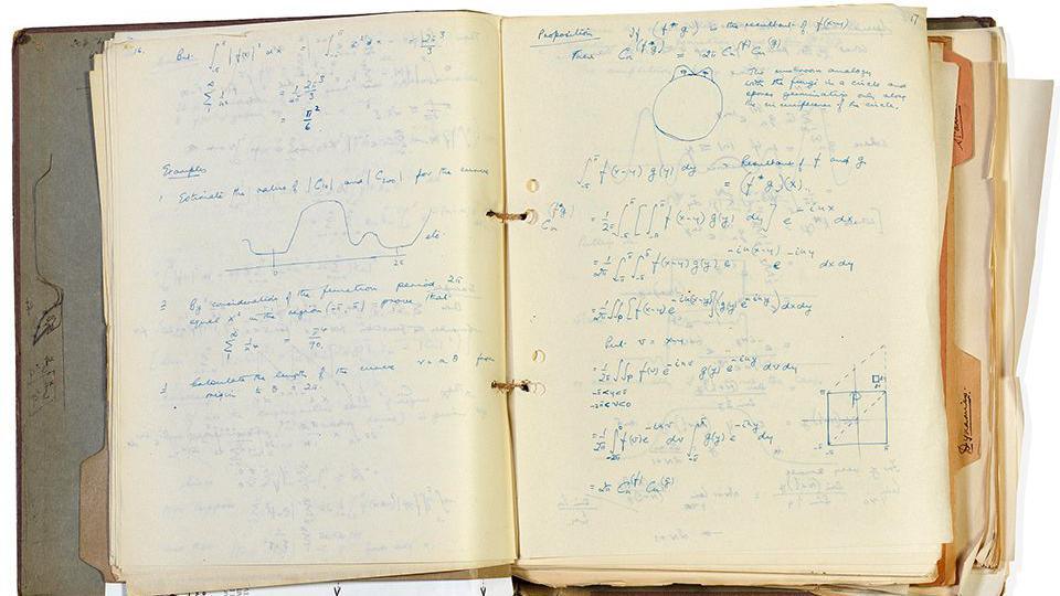 An open bound notebook with markings in blue ink