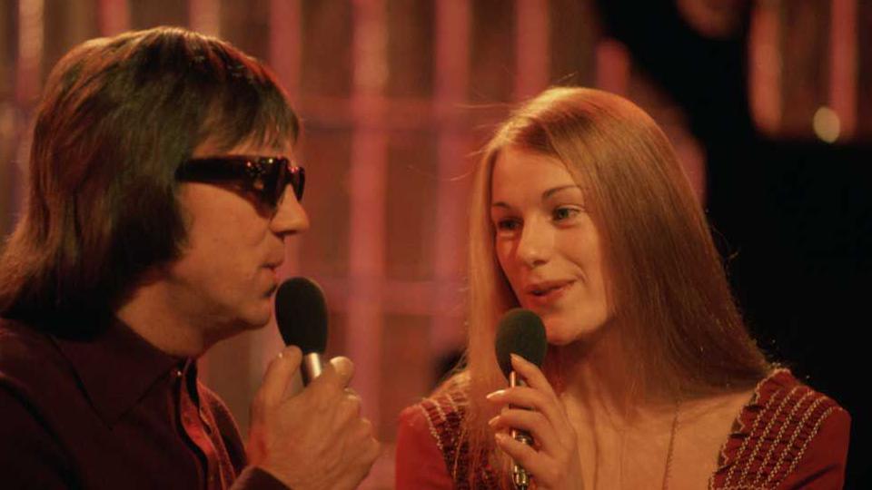 Peters, on the left in dark glasses and Lee, with long dark blonde hair and wearing a brown dress, singing on Top of the Pops in 1974