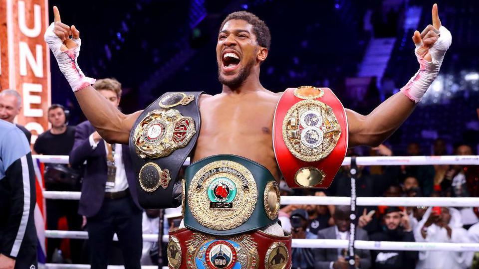 Joshua celebrates with the world title belt after beating Andy Ruiz Jr in their rematch in 2019