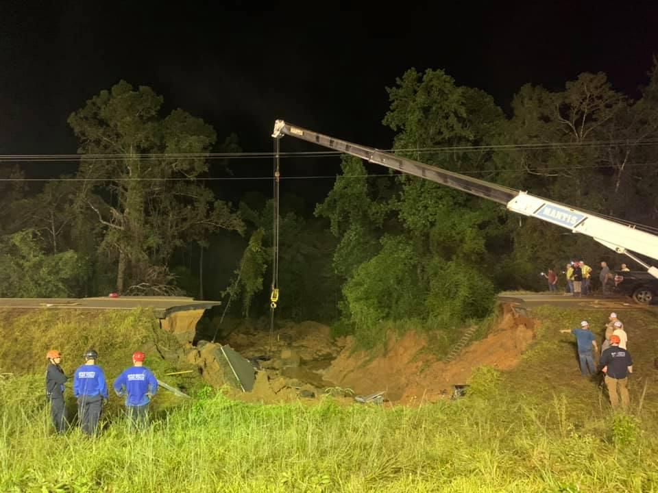 A crane is seen at the wreckage site of a highway collapse