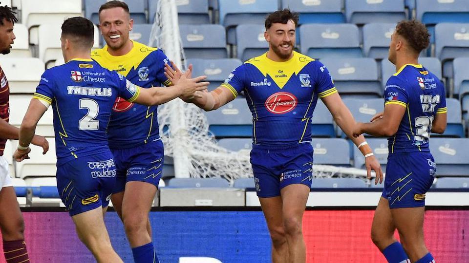 Matty Ashton celebrates his first try with his Warrington Wolves team-mates.