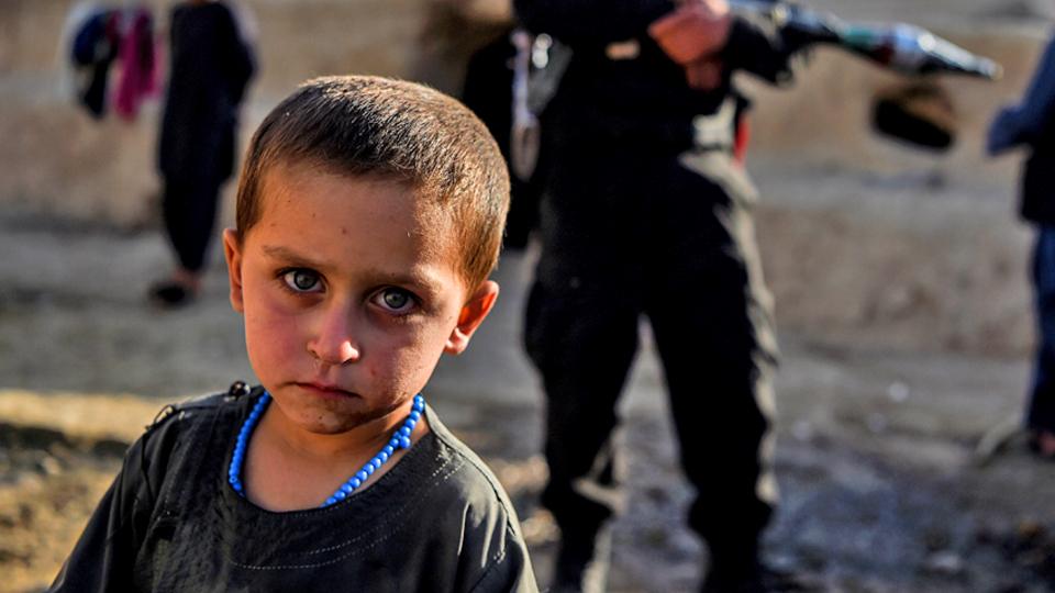 child-stares-as-man-holds-gun-behind-them