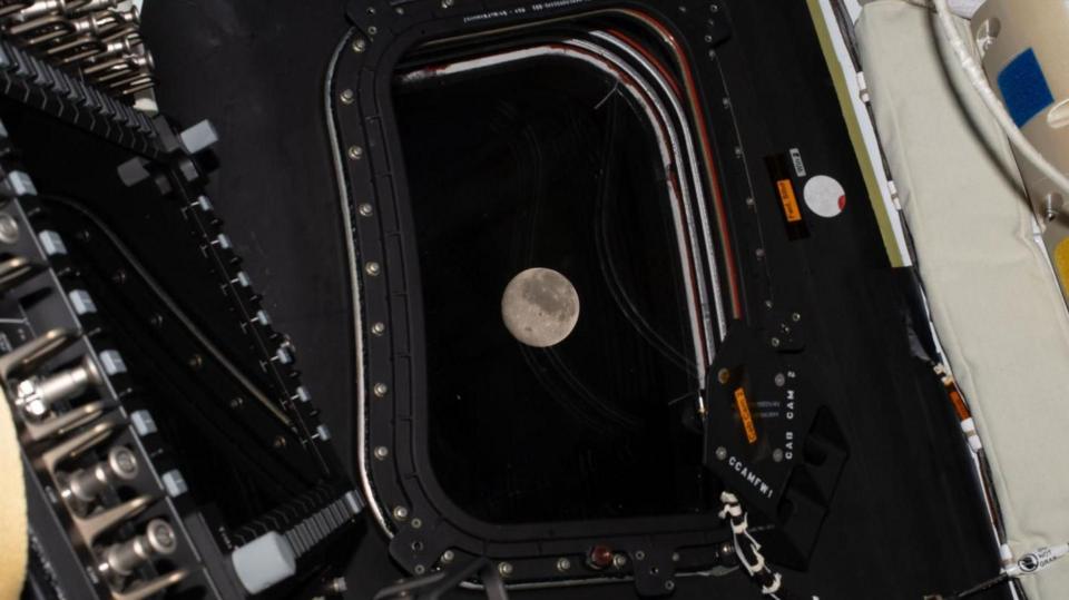 The Moon is pictured through a window of a spacecraft.