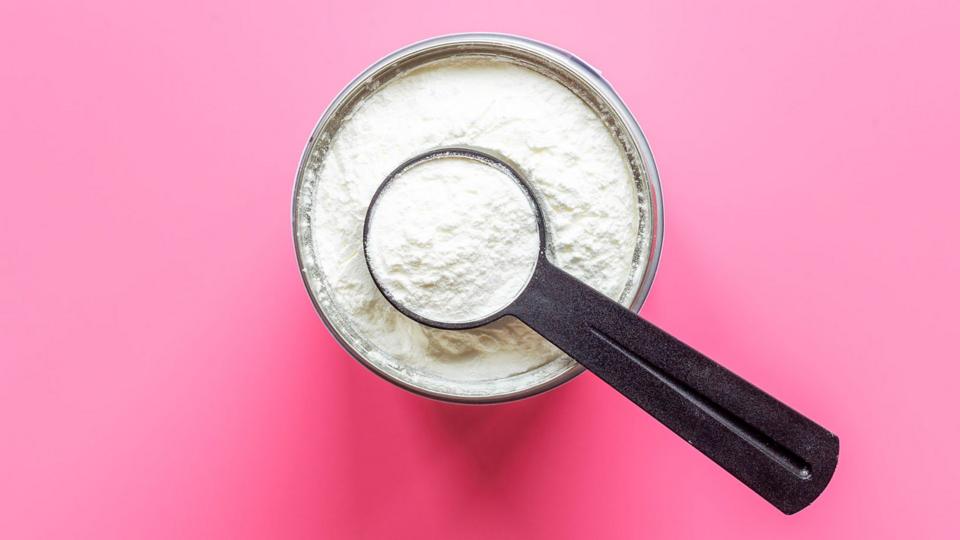 White powder in a silver bowl on a pink work surface