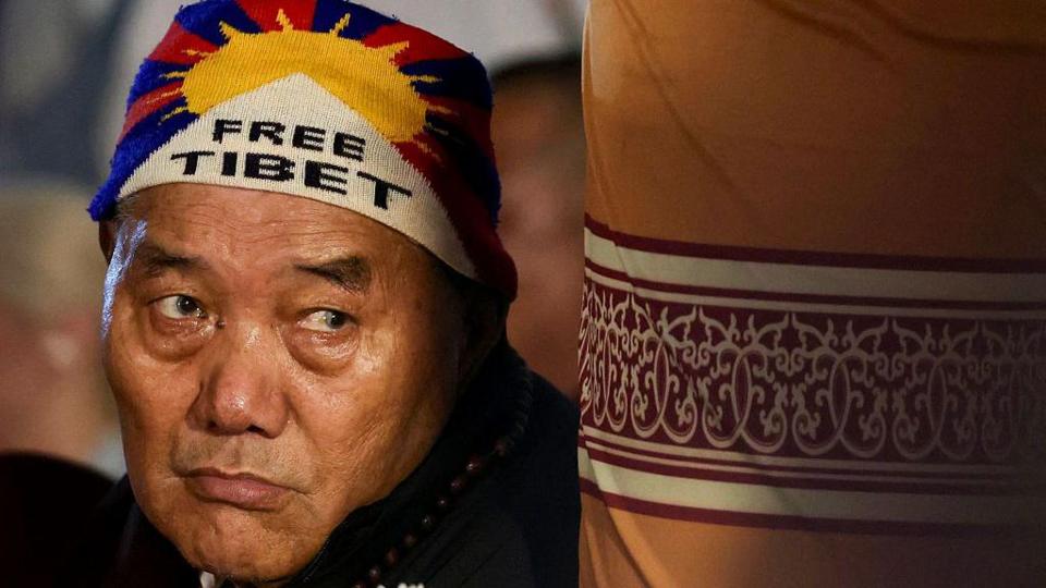 A devotee wearing 'Free Tibet' cap attends the Tibetan spiritual leader the Dalai Lama's prayer ceremony celebrating his 90th birthday at the Main Tibetan Temple in McLeod Ganj, near Dharamsala, on July 6, 2025.