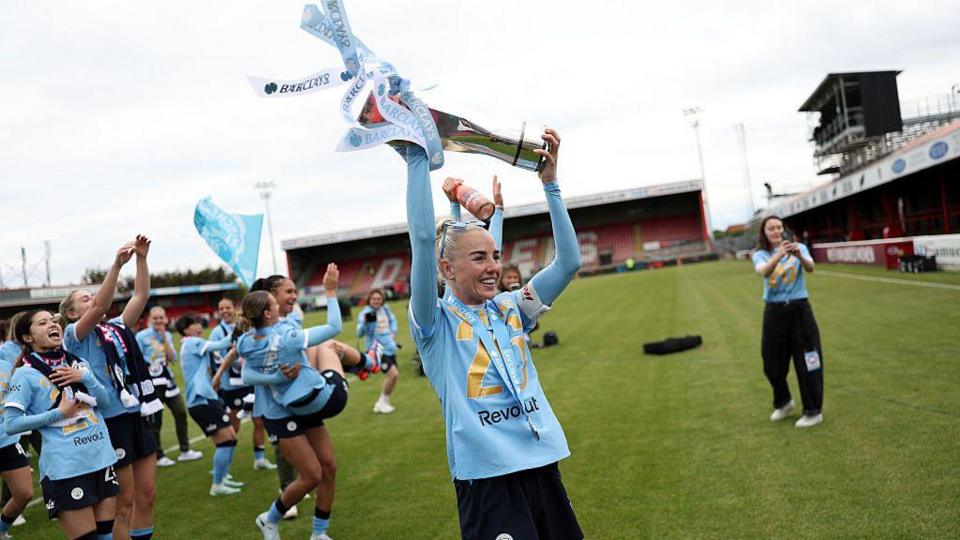 Alex Greenwood lifts the trophy in front of fans