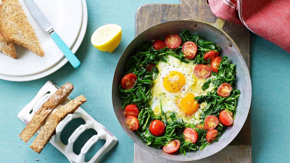 Poached eggs with spinach, tomatoes and a side of toast.