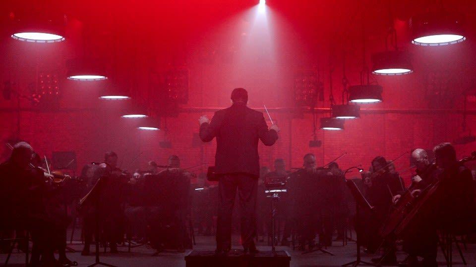 A conductor in front of an orchestra.