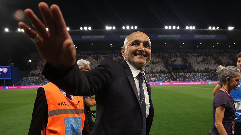 Luciano Spalletti raises a hand towards the camera