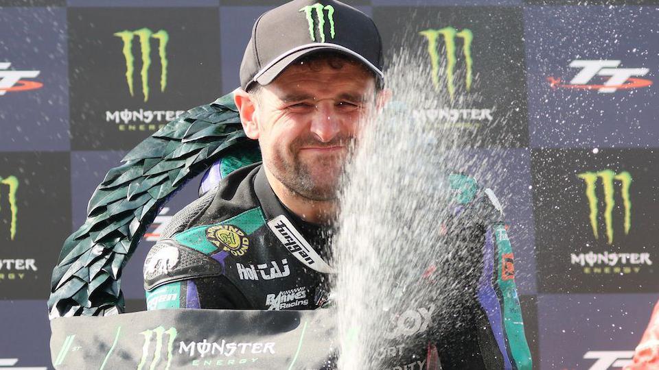 Michael Dunlop sprays champagne on the rostrum