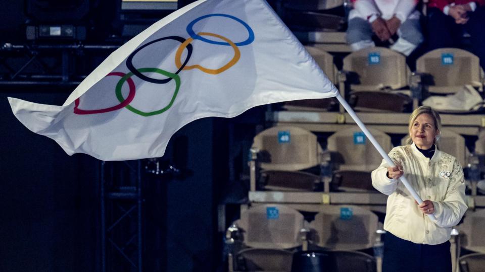 IOC president Kirsty Coventry waving an Olympic flag