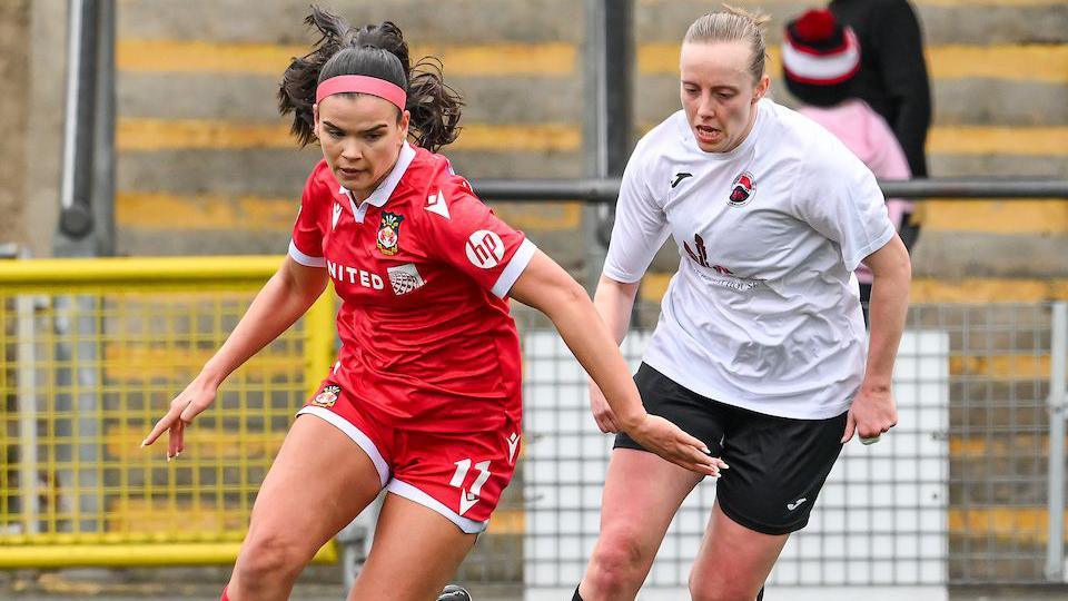 Amber Lightfoot (left) runs with the ball for Wrexham