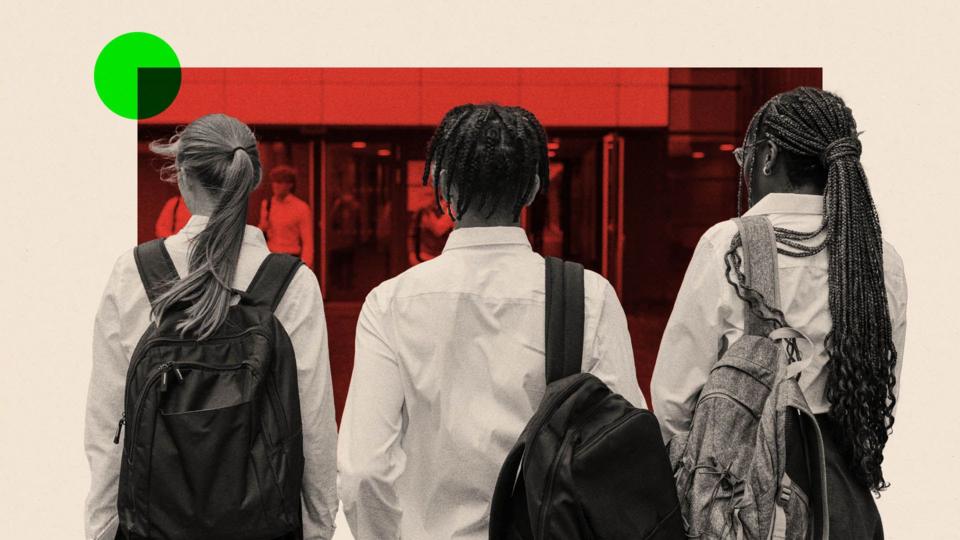 Students wearing school uniform, arriving at school for the day, walking side by side towards the entrance