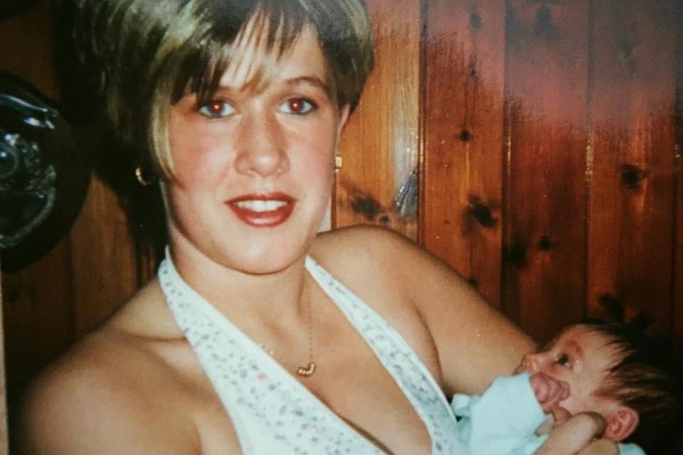 A vintage looking photograph showing a young mum holding her baby