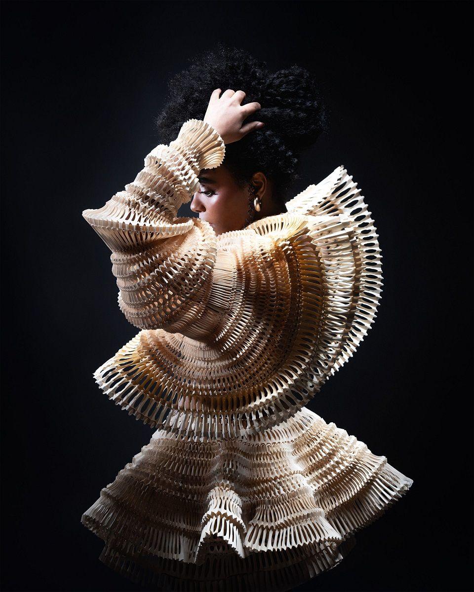 A woman wearing a dress created from paper art. 