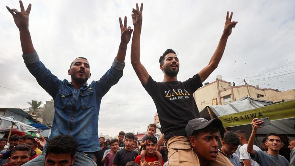 Palestinians celebrate in the streets after the ceasefire plan was approved.