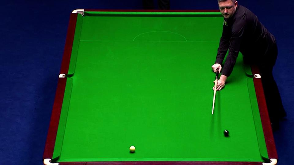 Kyren Wilson watching a black ball roll towards the pocket on a snooker table