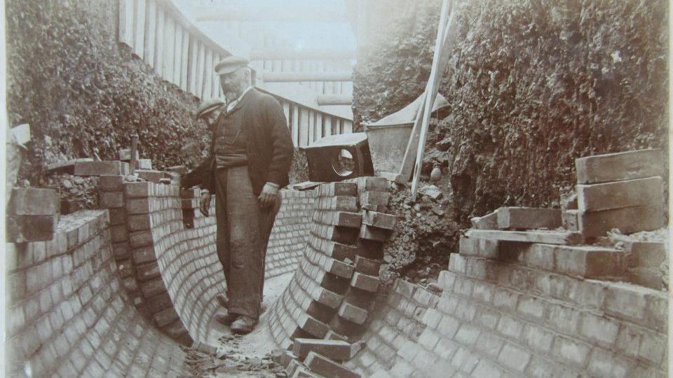 A black and white image showing two men laying bricks for Brighton's Victorian sewers