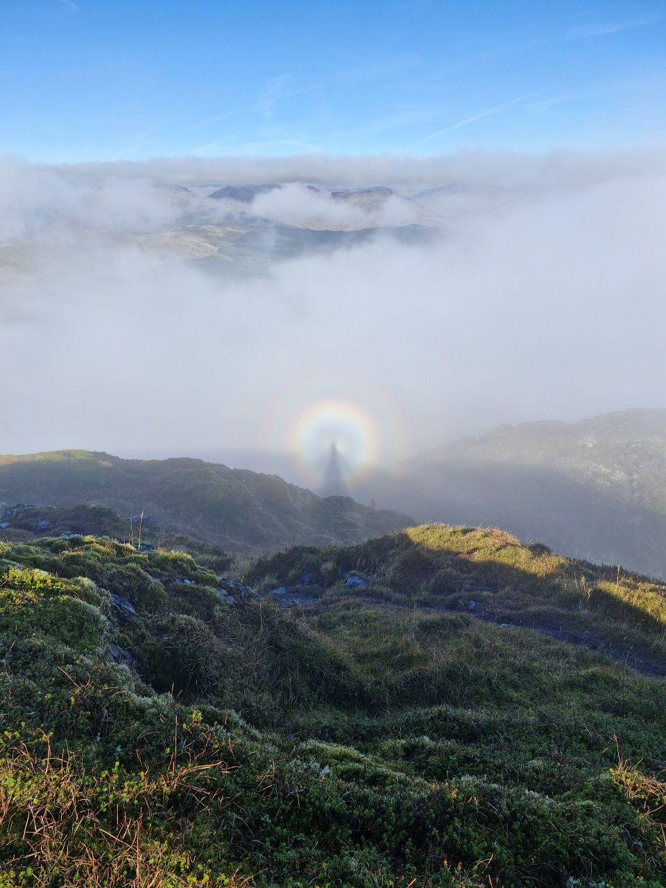 Green hills with a cloudy sky and a halo in the centre of the photo