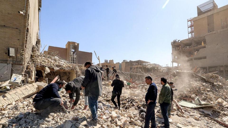 People in front of rubble in Tehran