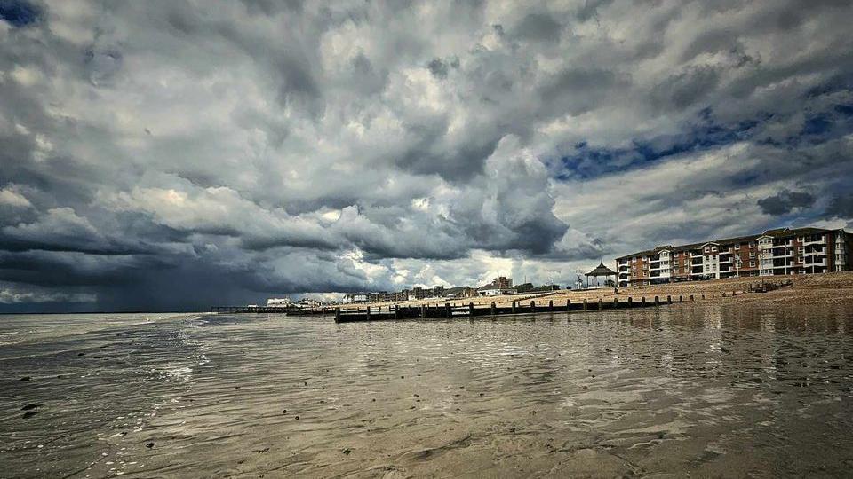 A beach with dark clouds over 