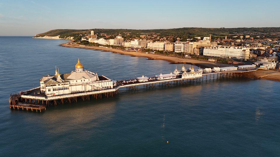 an ariel view of eastbourne pier. the pier is on the sea. buildings on the sea front.