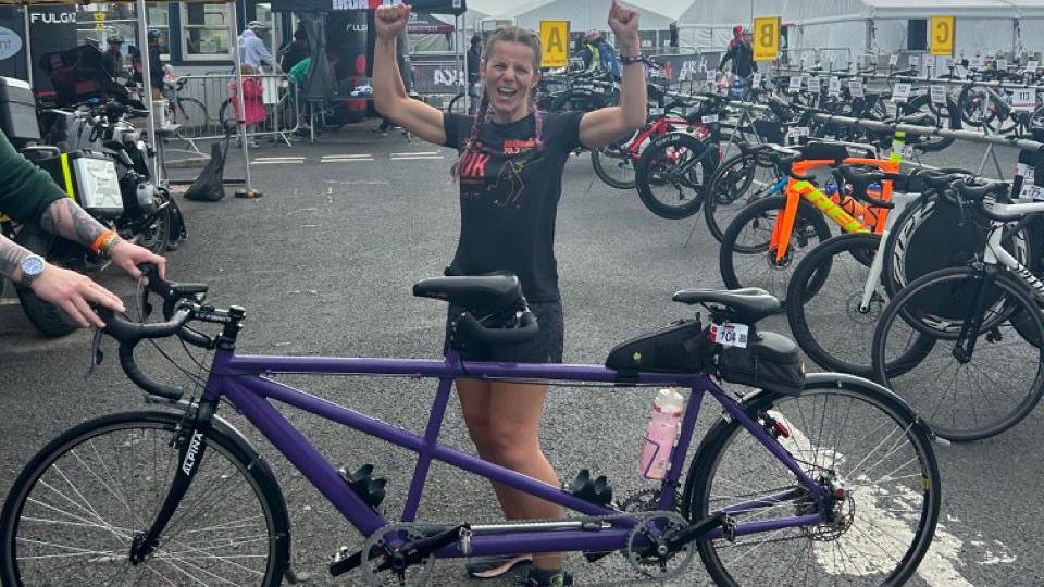 Ironman competitor Laura Whitaker stood with tandem bike cheering 